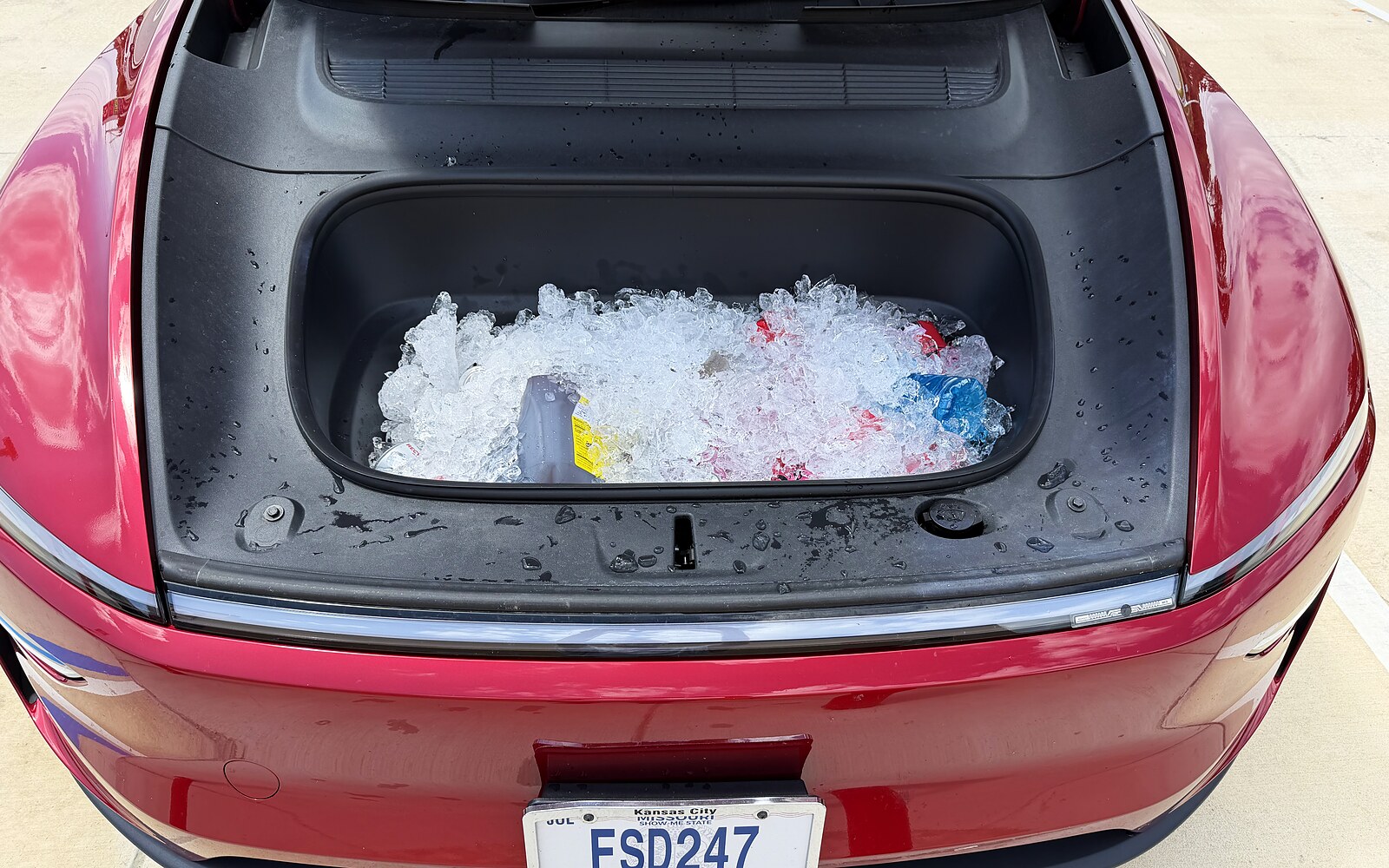 Tesla Model Y front trunk filled with ice and canned drinks, used as a cooler on a road trip.