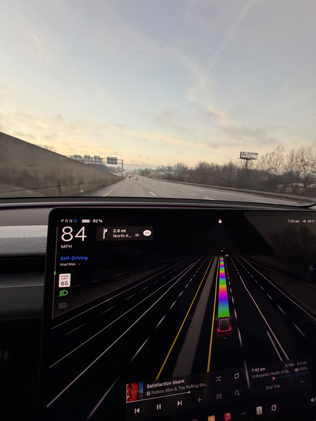 Tesla FSD drive display reading 84 mph with the posted limit at 65, heading into North Kansas City.