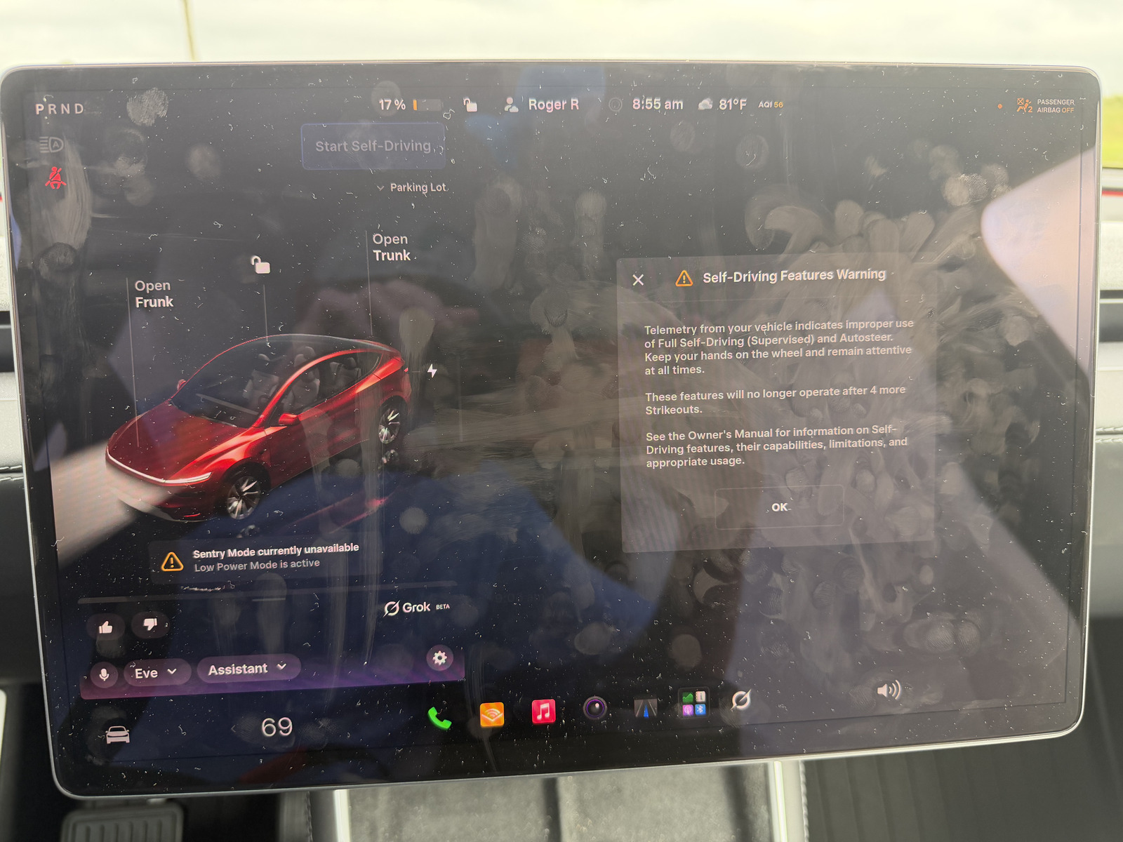 Tesla touchscreen at 17% battery showing Sentry Mode currently unavailable because Low Power Mode is active, with a Self-Driving warning dialog at the edge of the frame.