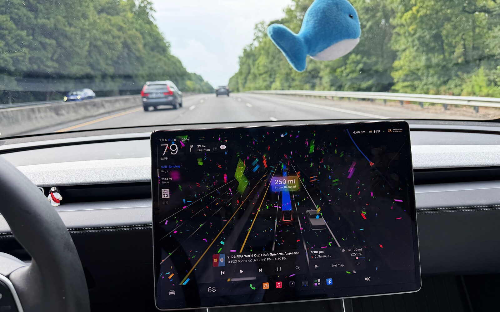 Tesla screen throwing confetti for a 250 mile FSD streak on I-65 in Alabama, 79 mph with the limit at 70.